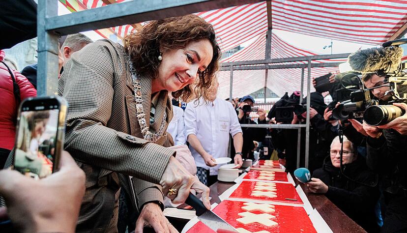 Amsterdams Bürgermeisterin Femke Halsema schneidet die lange Torte an. Amsterdams Bürgermeisterin Femke Halsema schneidet die lange Torte an.