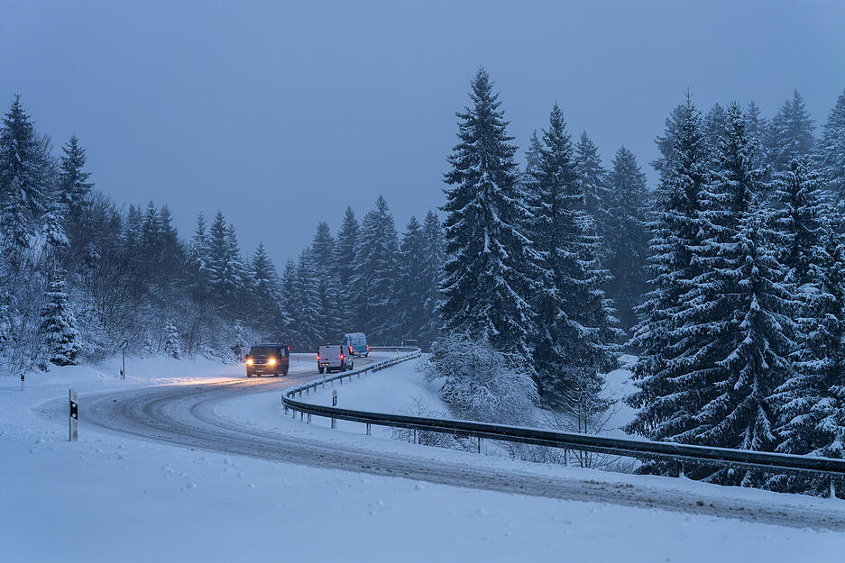 Autos fahren bei Vöhrenbach auf einer von Schnee bedeckten Straße. Autos fahren bei Vöhrenbach auf einer von Schnee bedeckten Straße.