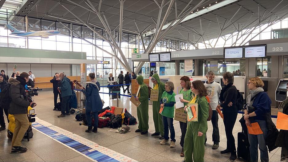 Der Chor Lebenslaune hat sich im Flughafen aufgestellt und singt.  Der Chor Lebenslaune hat sich im Flughafen aufgestellt und singt.