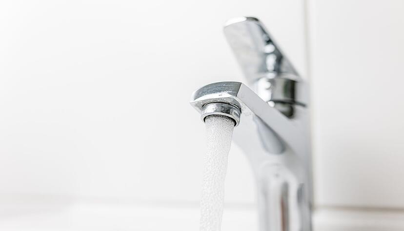 Wasser fließt durch einen geöffneten Hahn. Wasser fließt durch einen geöffneten Hahn.