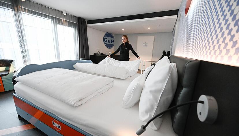 Eine Angestellte des V8 Hotels in Böblingen richtet ein Bett in einem Themenzimmer, in dem die Front eines Autos an ein Bett gestaltet ist. Eine Angestellte des V8 Hotels in Böblingen richtet ein Bett in einem Themenzimmer, in dem die Front eines Autos an ein Bett gestaltet ist.