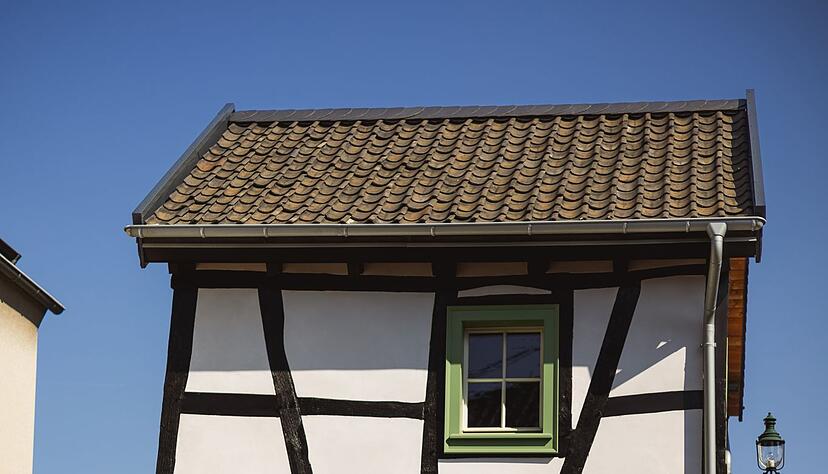 Altes Tiny House hinter neuem Tiny Car: Das rund 2,28 Meter lange Gef&auml;hrt spielt in der Innenstadt bei der Parkplatzsuche seine Tr&uuml;mpfe voll aus.