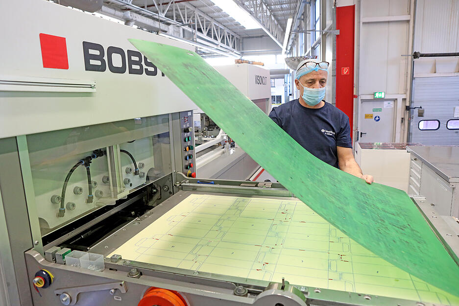 Miftari Rexhep an den Stanzwerkzeugen, die von Hand eingerichtet werden.