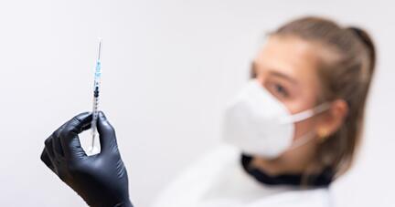 Die Mitarbeiterin eines Impfzentrums hält eine Spritze mit einem Impfstoff gegen Corona in der Hand. Die Mitarbeiterin eines Impfzentrums hält eine Spritze mit einem Impfstoff gegen Corona in der Hand.