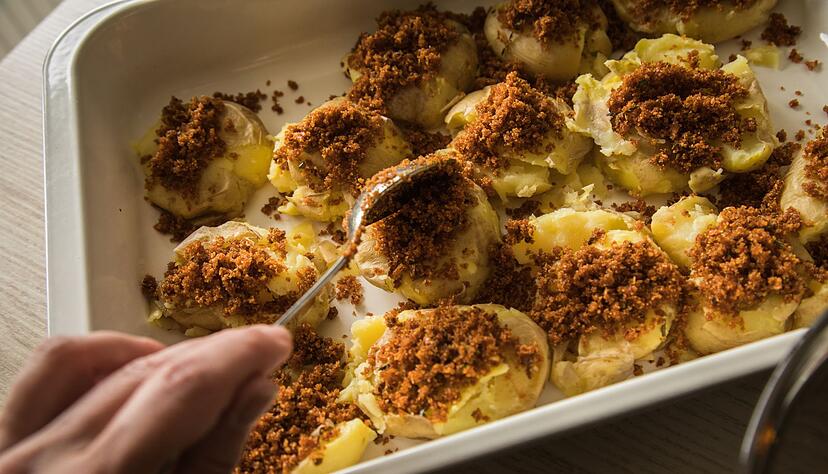 Sorgt f&uuml;r Knusper-Effekt: Auf die gequetschten Kartoffeln kommt eine Masse aus Pankomehl, ger&auml;uchertem Paprikapulver, Rosmarinnadeln, Thymian- und Salbeibl&auml;ttchen, Salz, Butter und Knoblauch.