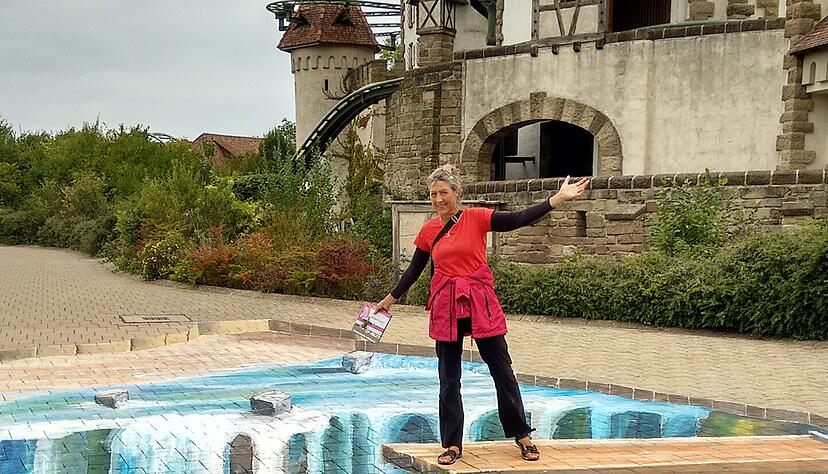 Künstlerin Marion Ruthardt aus Duisburg hat mit Fassadenfarbe ein Bild mit einem hölzernen Sprungbrett und einem Wasserfall auf den Boden gemalt. Foto: Friedhelm Römer