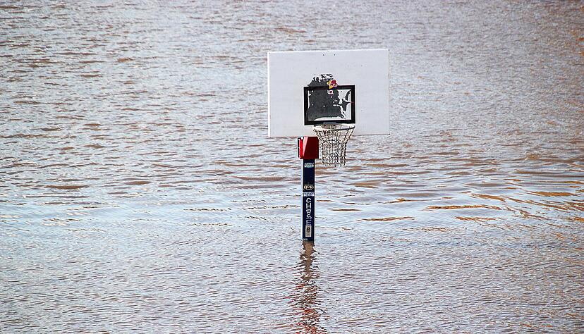 Ein Basketballkorb ist inmitten vom Wasser des Neckars zu sehen.
