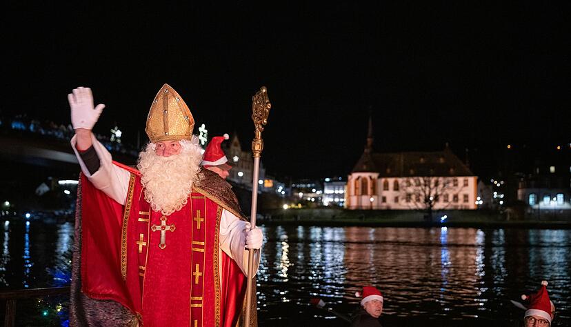 Von zahlreichen Fackelschwimmern begleitet ist der Nikolaus in Bernkastel-Kues in einem Ruderboot über die Mosel gekommen.
