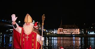 Von zahlreichen Fackelschwimmern begleitet ist der Nikolaus in Bernkastel-Kues in einem Ruderboot über die Mosel gekommen.