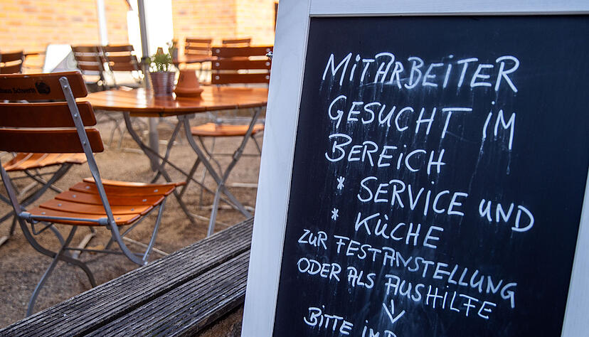 Auf einer Tafel vor einem Restaurant wird nach Mitarbeitern für den Service- und Küchenbereich gesucht. Foto: dpa