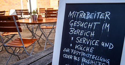 Auf einer Tafel vor einem Restaurant wird nach Mitarbeitern für den Service- und Küchenbereich gesucht. Foto: dpa