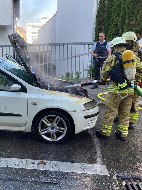 Feuerwehrleute l&ouml;schten den Brand im Motorraum.