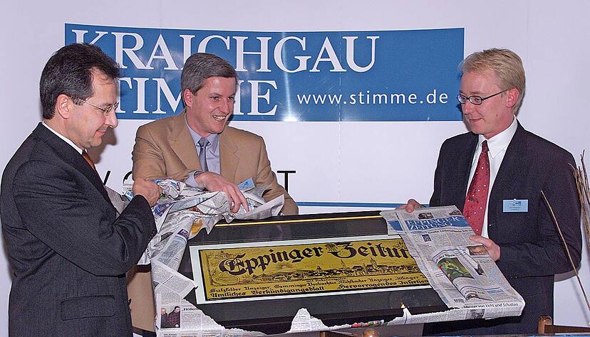 Das historische Schild der Eppinger Zeitung symbolisiert die Verbundenheit zu den lokalen Wurzeln. Der einstige Geschäftsführer Bernd Herzberger, der damalige Redaktionsleiter Uwe Ralf Heer und Verleger Tilmann Distelbarth (von links) enthüllten das Geschenk zur Zeitungsgründung.
Foto: Archiv/Veigel