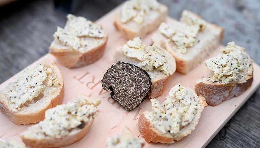 Der Burgundertrüffel, (Tuber unicatum) gilt ebenfalls als Delikatesse. Hier liegt ein Stück in der Mitte eines Holzbretts zwischen Appetithäppchen mit Trüffelbutter. Der Burgundertrüffel, (Tuber unicatum) gilt ebenfalls als Delikatesse. Hier liegt ein Stück in der Mitte eines Holzbretts zwischen Appetithäppchen mit Trüffelbutter.
