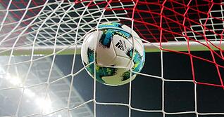 Ein Fußball geht ins Netz.