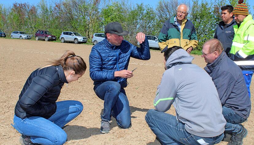 Veit Nübel von Südzucker (Mitte) untersucht, wie sich das Saatgut entwickelt hat. Aufgrund von Verschlämmung war der Boden steinhart.
Foto: Jörg Kühl Veit Nübel von Südzucker (Mitte) untersucht, wie sich das Saatgut entwickelt hat. Aufgrund von Verschlämmung war der Boden steinhart.
Foto: Jörg Kühl