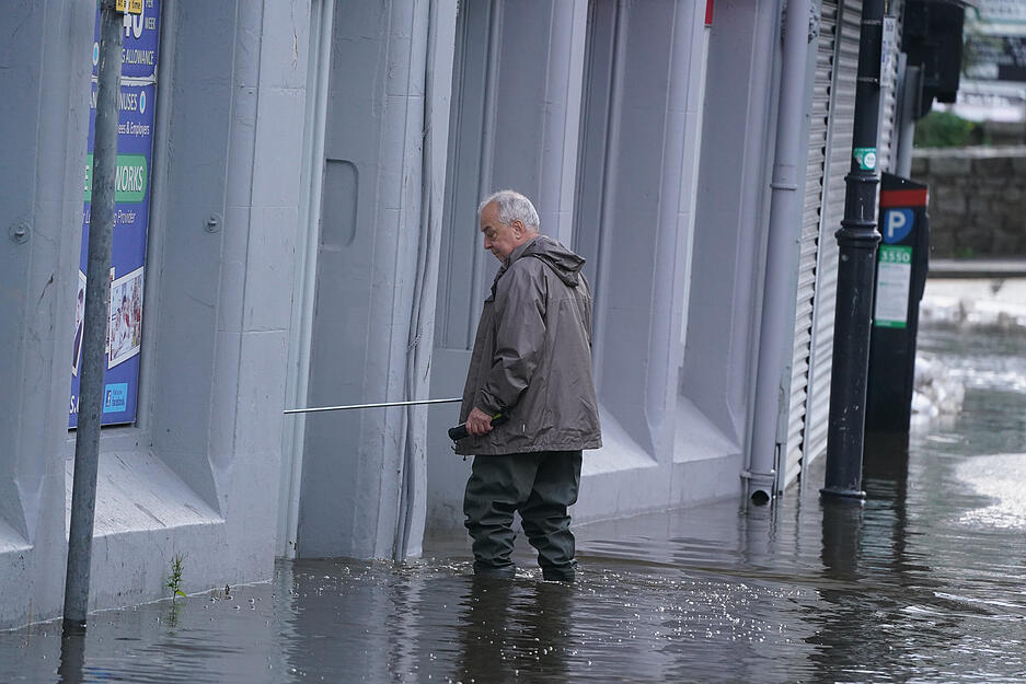 Ein Mann geht in Sugar Island durch das Hochwasser, nachdem der Kanal der Stadt bei heftigen Regenfällen über die Ufer getreten war.