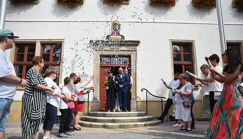 Menschen schie&szlig;en am Samstag (9.8.) Konfettikanonen in Richtung des Brautpaars.