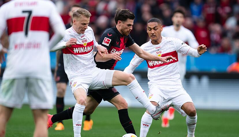 Leverkusens Jonas Hofmann (M) k&auml;mpft mit Stuttgarts Deniz Undav (l) und Enzo Millot um den Ball.