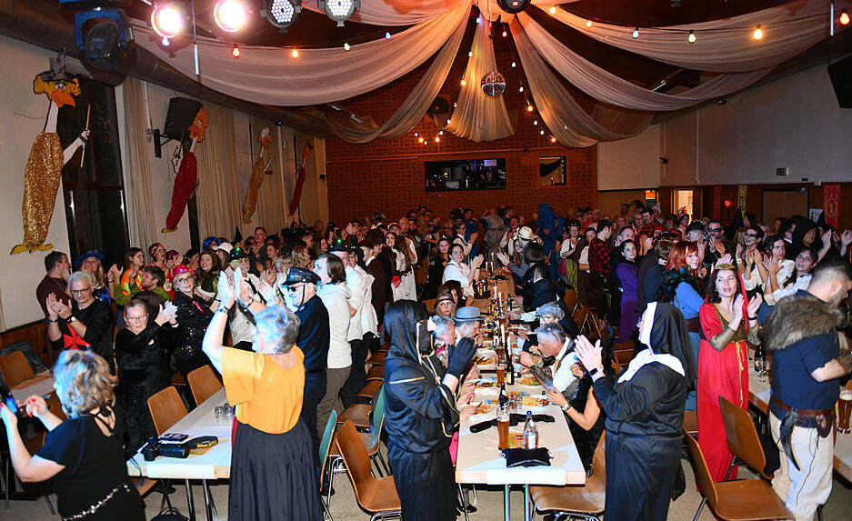 In der Jagstfelder Jahnhalle erheben sich die G&auml;ste bei der Prunksitzung der H&uuml;hnerl&auml;use von ihren Pl&auml;tzen.