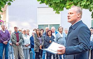 Auf dem Dorfplatz: Pfarrer Jochen Rexer am Gedenkstein.