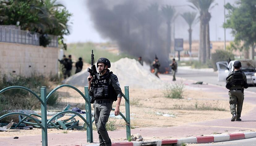 Israelische Soldaten gehen nach dem Hamas-Terrorangriff durch einen Grenzort. Israelische Soldaten gehen nach dem Hamas-Terrorangriff durch einen Grenzort.
