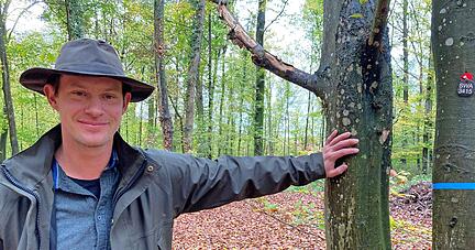 Der studierte Förster Torben Lenhart betreut acht Friedwälder. Die rote Plakette an der blau-bebänderten Buche zeigt ihren Preis an: 4490 Euro.