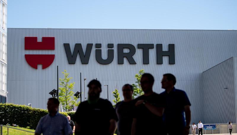 Mitarbeiter des Handelskonzern Würth stehen vor dem Logo des Unternehmens. Mitarbeiter des Handelskonzern Würth stehen vor dem Logo des Unternehmens.