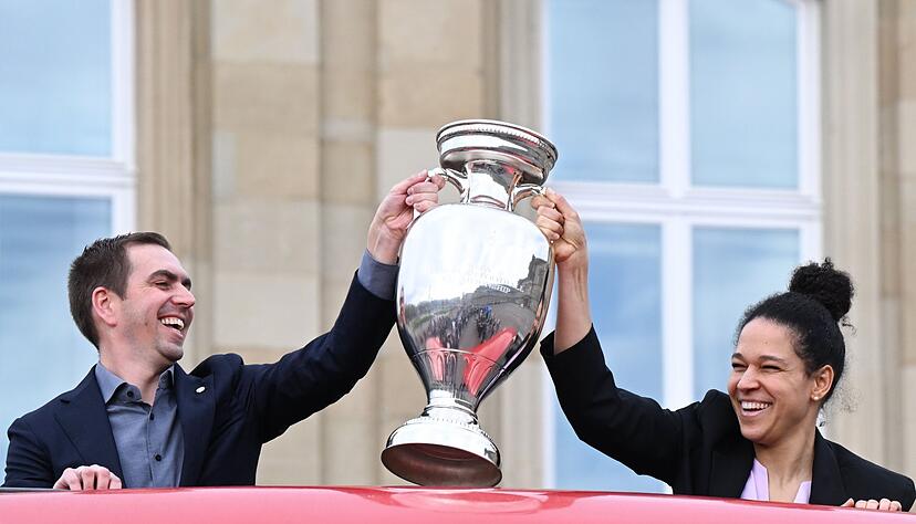 Philipp Lahm, Turnierdirektor der Fußball-Europameisterschaft, hält zusammen mit der früheren Fußball Nationalspielerin Celia Sasic den EM-Pokal hoch.
