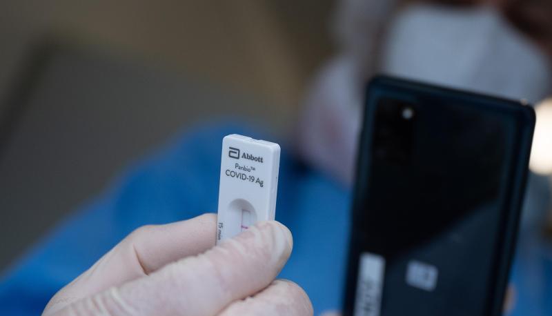 Eine Mitarbeiterin einer Schnellteststation scannt einen Schnelltest.