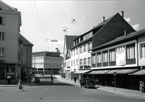 1953: Die Fleiner Straße ist für den Verkehr freigegeben. Links im Bild die Milchbar und Reklame für den Filmpalast, rechts von vorn damals: Hippel, Heinzelmann, Bechtel, Gaststätte Steineck, Juwelier Stotz und Brenner-Schilling. Im Hintergrund sichtbar Merkur. Bereits 1952 übernimmt die Düsseldorfer Horten AG das Kaufhaus in Heilbronn.