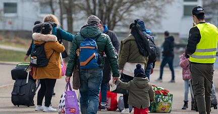 Neuankömmlinge gehen in einer Landeserstaufnahmestelle (LEA) zu ihrem Quartier.