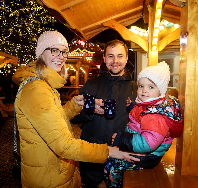 Besucher des Weihnachtsmarktes stoßen mit Heißgetränken auf die Eröffnung an. Besucher des Weihnachtsmarktes stoßen mit Heißgetränken auf die Eröffnung an.