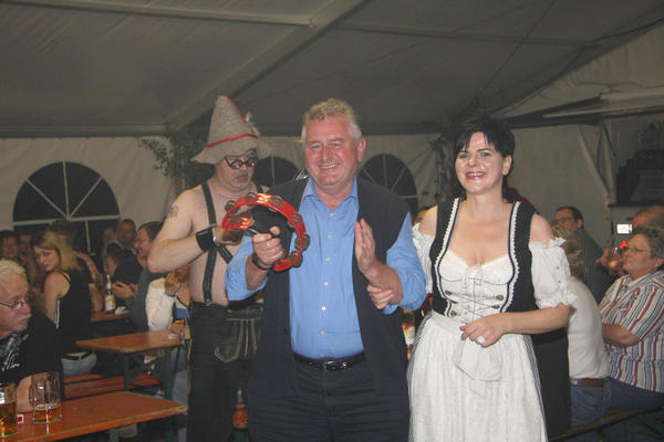 Bernhard Schwarz, Vorsitzender des VfB Neuhütten, wird von der Kapelle zum Musizieren aufgefordert.