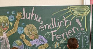 Erst- und Zweitklässler malen in der Grundschule ein Bild an die Tafel. Erst- und Zweitklässler malen in der Grundschule ein Bild an die Tafel.