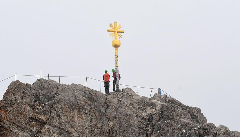 Bergsteiger stehen neben dem Gipfelkreuz des Zugspitzgipfel. Bergsteiger stehen neben dem Gipfelkreuz des Zugspitzgipfel.