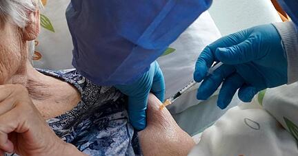 Eine Heimbewohnerin einer Seniorenresidenz in Sachsen-Anhalt erhält ihre Drittimpfung gegen das Corona-Virus.