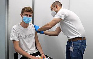 Dennis Beck bekommt von Dr. Tobias Neuwirth seine Erstimpfung. Der 21-Jährige hofft auf ein unbeschwerteres Zusammensein mit den Freunden. Fotos: Christian Nick