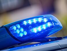 Ein Blaulicht ist auf dem Dach eines Polizeifahrzeugs zu sehen.