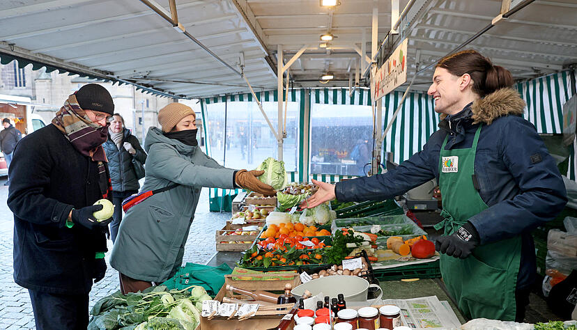 Händler und Kunden müssen sich warm einpacken: Isabella Kappus und Michael Drescher kaufen Obst und Gemüse auf dem Heilbronner Wochenmarkt bei eisigen Temperaturen ein.