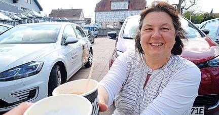 Anja Leipold mit einem Kaffee am Untergruppenbacher Rathausplatz: So lässt sich die Ladezeit sinnvoll nutzen.