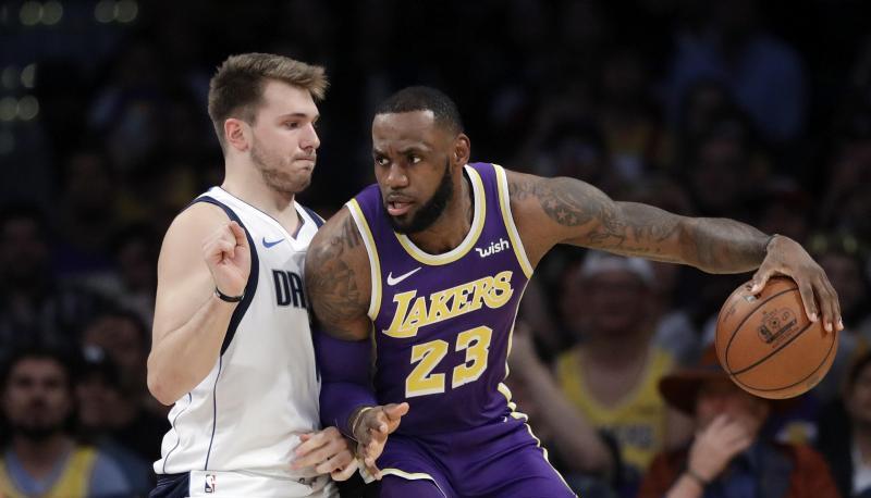 Jungstar Luka Doncic (l) von den Mavericks verteidigt gegen Lakers-Star LeBron James.