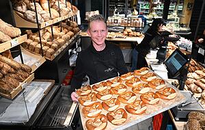 Jochen Baier von der B&auml;ckerei Baier verkauft in seiner Filiale in der Stuttgarter Markthalle gespritzte Butterbrezeln.