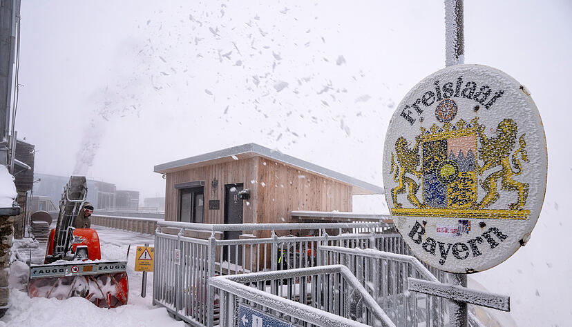 Neuschnee in Bayern: Eine Frau räumt Schnee auf der Aufsichtsplattform der Zugspitze.
