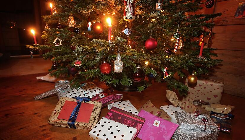 Weihnachtsgeschenke unter einem geschmückten Weihnachtsbaum.