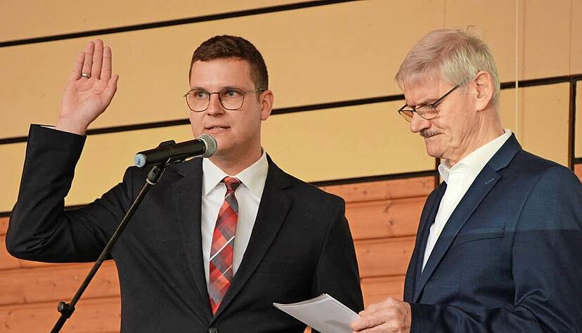 Der erste stellvertretende Bürgermeister Ulrich Karle (rechts) vereidigt Michael Foss für seine zweite Amtszeit als Forchtenberger Bürgermeister.