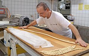In der Backstube ist gro&szlig;e Ausdauer gefragt: Mit viel Geschick schlingt Meister Albrecht Clau&szlig; die langen d&uuml;nnen Str&auml;nge zu gleichm&auml;&szlig;ig geformten Brezeln. Foto: Elke Khattab