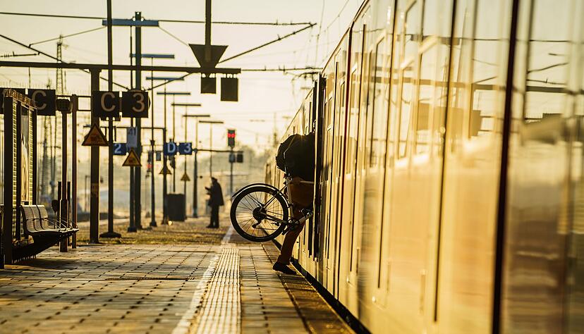 Ein Fahrgast steigt mit seinem&nbsp;Rad in eine Bahn.