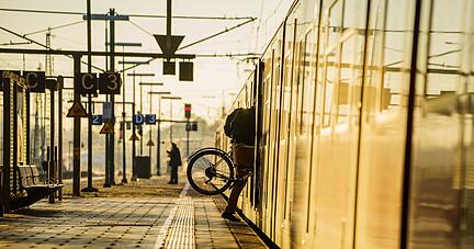 Ein Fahrgast steigt mit seinem&nbsp;Rad in eine Bahn.