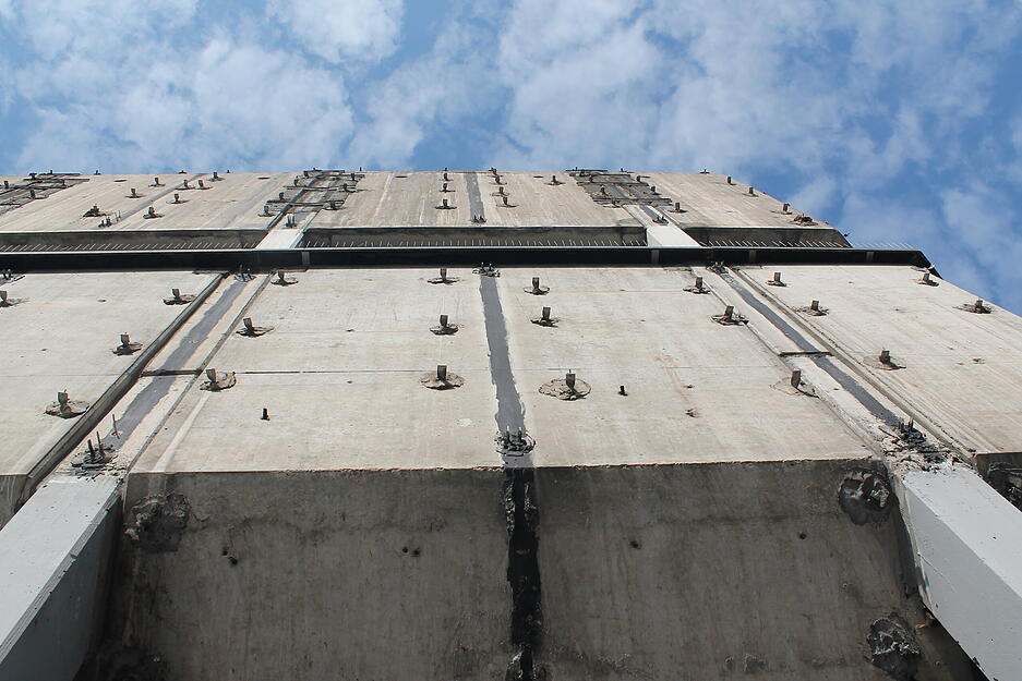Unter den Fassadeplatten kamen Metallenden, die wie Dornen von dem Gebäude abstehen, hervor. Unter den Fassadeplatten kamen Metallenden, die wie Dornen von dem Gebäude abstehen, hervor.